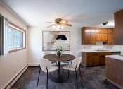Thumbnail 2 of 20 - a kitchen and dining room with a table and chairs and a ceiling fan. Fargo, ND Martha Alice Apartments