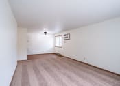 Thumbnail 10 of 26 - the living room and dining room of an apartment with carpet and white walls. Fargo, ND Monticello Apartments