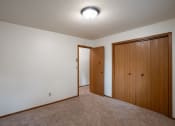 Thumbnail 21 of 26 - a bedroom with carpet and a door to a closet. Fargo, ND Monticello Apartments