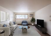 Thumbnail 1 of 26 - a living room with a couch and a table and a tv. Fargo, ND Monticello Apartments