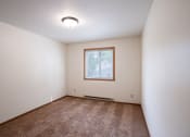 Thumbnail 15 of 26 - an empty living room with carpet and a window. Fargo, ND Monticello Apartments