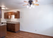 Thumbnail 13 of 26 - an empty kitchen with wooden cabinets and a ceiling fan. Fargo, ND Monticello Apartments