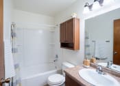 Thumbnail 13 of 15 - a bathroom with a sink toilet and shower and a mirror. Fargo, ND Morningside Apartments