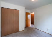 Thumbnail 11 of 15 - an empty living room with a door to a hallway and a closet. Fargo, ND Morningside Apartments