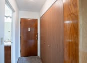 Thumbnail 12 of 15 - a hallway with a wooden door and a bathroom with a sink. Fargo, ND Morningside Apartments