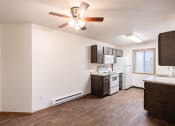 Thumbnail 23 of 31 - an empty living room with a kitchen and a ceiling fan. Fargo, ND Oxford Apartments
