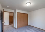 Thumbnail 15 of 31 - an empty living room with carpet and a door to a closet. Fargo, ND Oxford Apartments