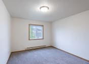 Thumbnail 16 of 31 - the living room of an empty room with carpet and a window. Fargo, ND Oxford Apartments