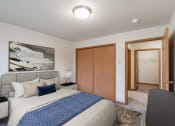 Thumbnail 4 of 31 - a bedroom with a bed and a closet and a door to a bathroom. Fargo, ND Oxford Apartments
