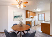 Thumbnail 2 of 31 - a dining room with a table and chairs and a kitchen. Fargo, ND Oxford Apartments