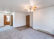 Thumbnail 14 of 31 - the living room and dining room of an empty house with a ceiling fan. Fargo, ND Oxford Apartments