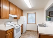 Thumbnail 13 of 31 - a kitchen with white appliances and wooden cabinets. Fargo, ND Oxford Apartments