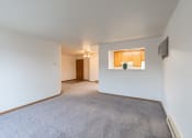 Thumbnail 9 of 31 - the living room and dining room of an apartment with white walls and carpet. Fargo, ND Oxford Apartments