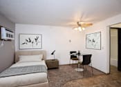 Thumbnail 7 of 28 - a bedroom with a bed and a desk and a ceiling fan