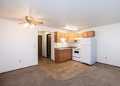 Thumbnail 25 of 28 - a kitchen with white appliances and wooden cabinets and a ceiling fan. Fargo, ND Pacific Park 2