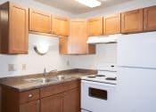 Thumbnail 23 of 28 - a kitchen with white appliances and wooden cabinets. Fargo, ND Pacific Park 2