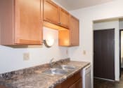 Thumbnail 26 of 28 - a kitchen with wood cabinets and granite counter tops and a sink. Fargo, ND Pacific Park 2