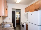Thumbnail 27 of 28 - a kitchen with white appliances and wooden cabinets and a refrigerator. Fargo, ND Pacific Park 2
