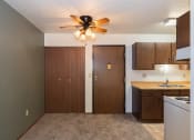 Thumbnail 10 of 28 - an empty kitchen with a ceiling fan and a door to a closet. Fargo, ND Pacific Park 2