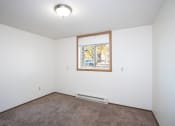 Thumbnail 10 of 22 - an empty room with carpet and a window. Fargo, ND Pacific Park Apartments