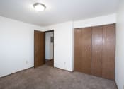 Thumbnail 11 of 22 - a bedroom with a closet and a door to a hallway. Fargo, ND Pacific Park Apartments