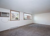 Thumbnail 8 of 22 - the living room of an apartment with carpet and a window. Fargo, ND Pacific Park Apartments