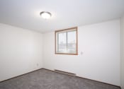 Thumbnail 15 of 22 - an empty room with a window and carpet. Fargo, ND Pacific Park Apartments