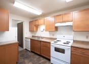 Thumbnail 14 of 22 - a kitchen with wood cabinets and white appliances. Fargo, ND Pacific Park Apartments