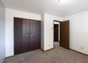 Thumbnail 18 of 22 - an empty living room with a wardrobe and a door to a hallway. Fargo, ND Pacific Park Apartments