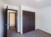 Thumbnail 20 of 22 - a bedroom with a closet and a door to a hallway. Fargo, ND Pacific Park Apartments