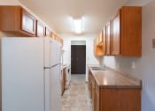 Thumbnail 17 of 22 - a kitchen with white appliances and wooden cabinets. Fargo, ND Pacific Park Apartments