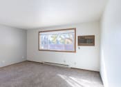 Thumbnail 16 of 22 - an empty living room with carpet and a window. Fargo, ND Pacific Park Apartments