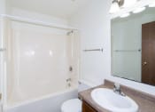 Thumbnail 14 of 18 - a bathroom with a sink and a shower and a mirror. Fargo, ND Pacific South Apartments