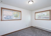 Thumbnail 13 of 18 - a bedroom with two windows and a carpet. Fargo, ND Pacific South Apartments