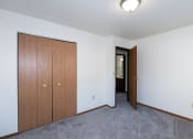 Thumbnail 12 of 18 - a bedroom with a closet and carpeted floors. Fargo, ND Pacific South Apartments