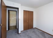 Thumbnail 10 of 18 - an empty room with a closet and a door to a bathroom. Fargo, ND Pacific South Apartments