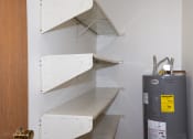 Thumbnail 15 of 18 - a small pantry with white shelving and a water heater. Fargo, ND Pacific South Apartments