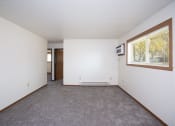 Thumbnail 5 of 18 - an empty living room with a large window and white walls. Fargo, ND Pacific South Apartments