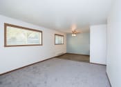 Thumbnail 6 of 18 - an empty living room with a ceiling fan and a window. Fargo, ND Pacific South Apartments