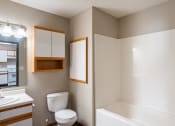 Thumbnail 15 of 16 - a bathroom with a toilet and a sink and a bath tub