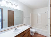 Thumbnail 14 of 19 - a bathroom with a sink toilet and shower and a mirror. Fargo, ND Rosegate Apartments