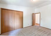 Thumbnail 13 of 19 - an empty living room with a door to a bedroom and a closet. Fargo, ND Rosegate Apartments