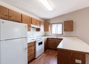 Thumbnail 8 of 19 - an updated kitchen with white appliances and wooden cabinets. Fargo, ND Rosegate Apartments