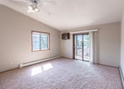 Thumbnail 6 of 19 - an empty living room with a sliding glass door to a balcony. Fargo, ND Rosegate Apartments