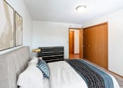 Thumbnail 4 of 19 - a bedroom with a bed and a closet and a door to a bathroom. Fargo, ND Rosegate Apartments