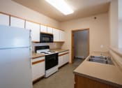 Thumbnail 51 of 61 - a kitchen with white appliances and a sink and a refrigerator. West Fargo, ND West Lake Apartments 11A