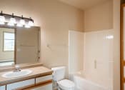 Thumbnail 56 of 61 - the view of a bathroom with a toilet sink and tub and a mirror. West Fargo, ND West Lake Apartments 11A