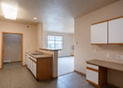 Thumbnail 50 of 61 - an empty kitchen with a sink and a door to a living room. West Fargo, ND West Lake Apartments 11A | BedroomWest Fargo, ND West Lake Apartments 11A | Kitchen