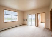 Thumbnail 48 of 61 - the living room of an empty house with a door and a window. West Fargo, ND West Lake Apartments 11A