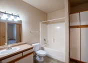 Thumbnail 38 of 61 - a bathroom with a shower toilet and sink and a mirror. Fargo, ND West Lake Apartments